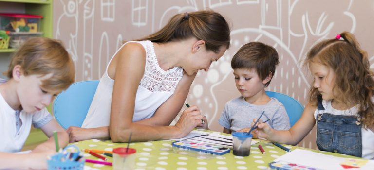 teacher-helping-kid-paint